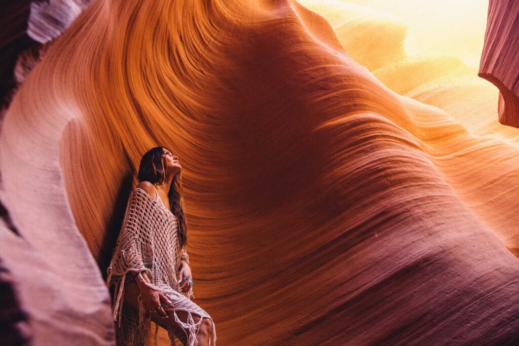 woman-looking-up-at-sunlight-in-cave-antelope-can1-XK8NCEF.jpg